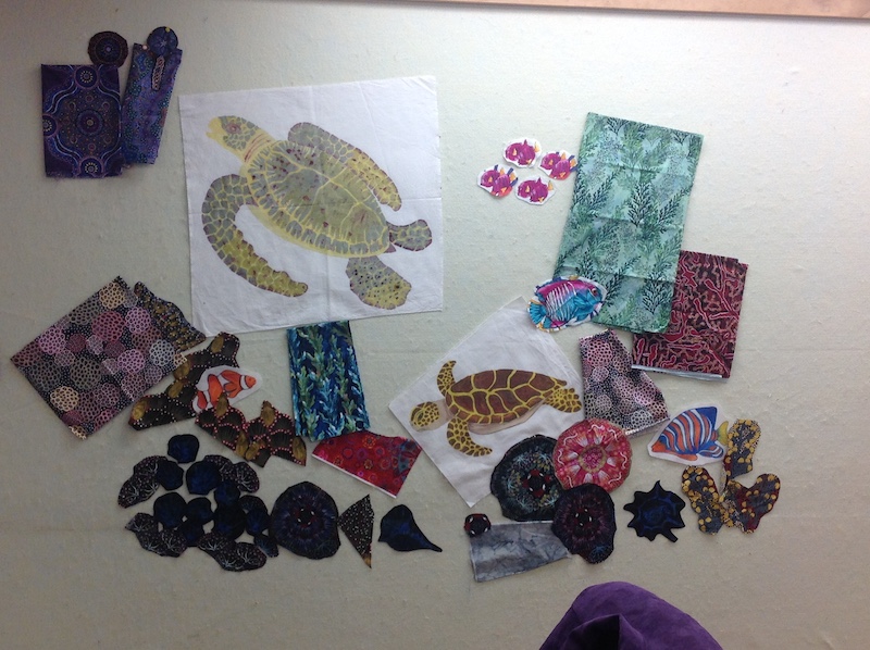 Fabric scraps and painted sea turtles on fabric as elements of art quilt in progress