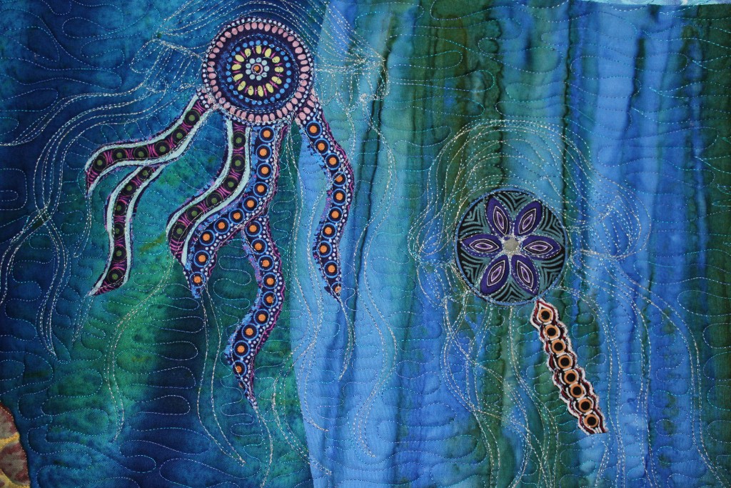 Art quilt detail showing two jellyfish made from Australian fabric and machine quilting with metallic thread