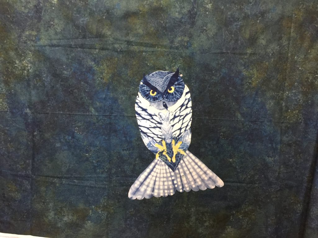 In progress art quilt with body of owl floating on background fabric