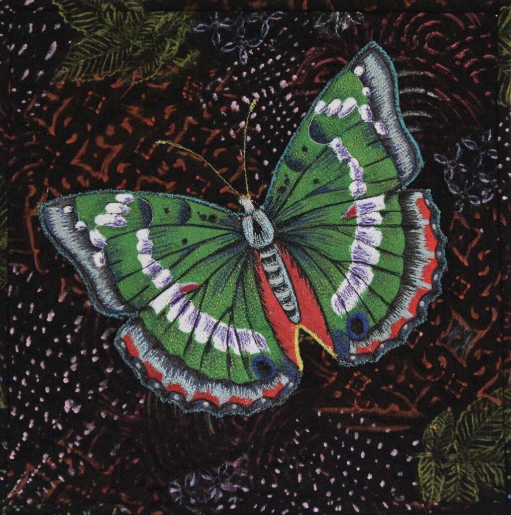 Small art quilt with green butterfly on black background