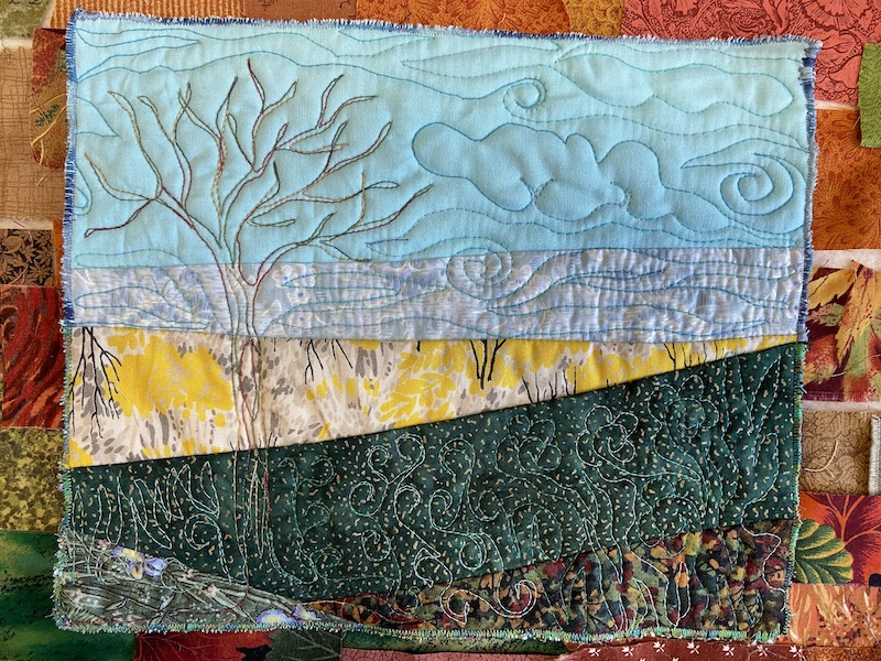 small art quilt sketch with blue sky, tree and green grass area