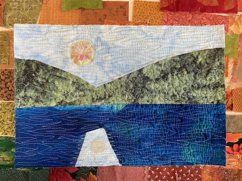 art quilt sketch of two green mountains coming together next to water Moon shining between mountains and reflected in water.