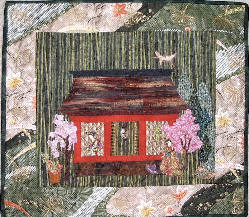 Small art quilt with Japanese tea house standing in a bamboo grande with the hint of paths alongside.